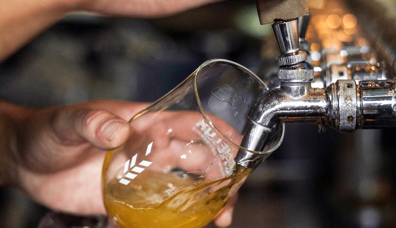 Glass of beer being poured from tap at Benelux - best brewpubs in montreal