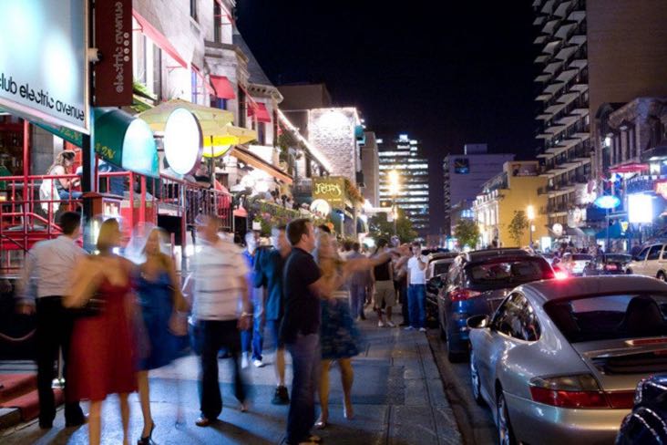 Enterrement de vie de garçon à Montréal Crescent Street la nuit avec beaucoup de piétons et de bars