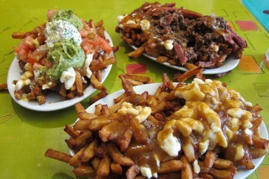 Three plates of poutine with different toppings such as ground beef, bacon and guacamole