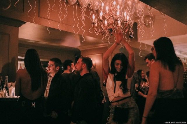 Young woman dances under the chandelier with lots of balloons at Mayfair cocktail bar