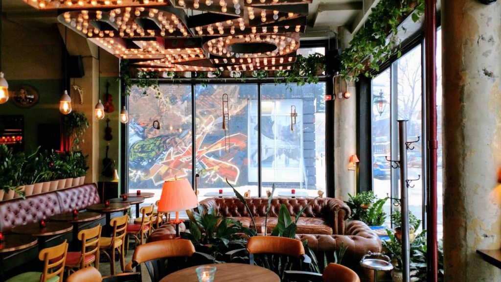 Intérieur du Bar Darling Montréal avec des plantes et un canapé - Les meilleures brasseries de Montréal